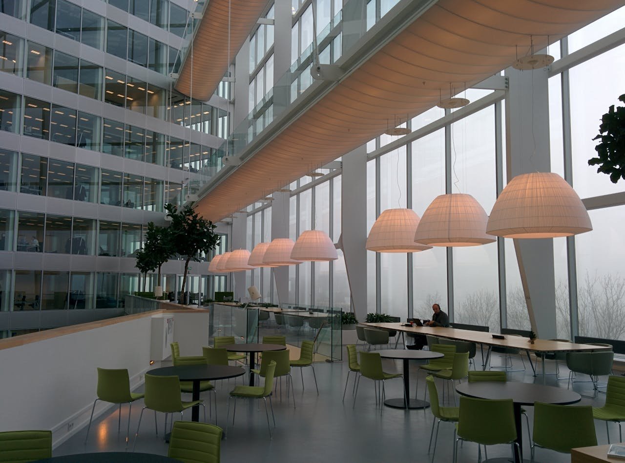 Contemporary office interior with large windows and stylish furniture, featuring a foggy exterior view.